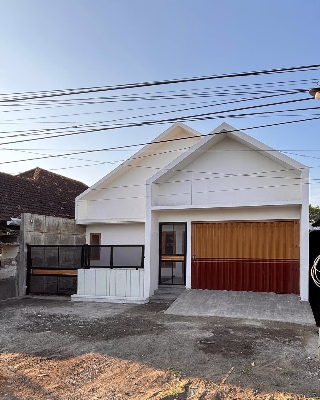 Fanji House - tampak frontal dengan teras pagar besi + jendela kayu solid